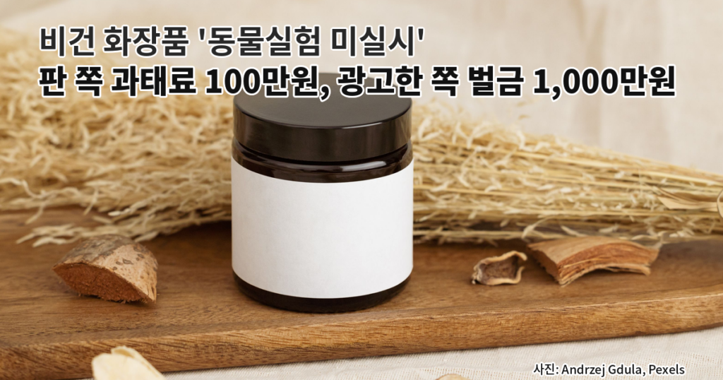 빈 흰색 라벨이 붙은 갈색 유리 화장품 용기가 원목 트레이 위에 놓이고 주변에 마른 식물과 씨앗이 흩어진 정물 사진